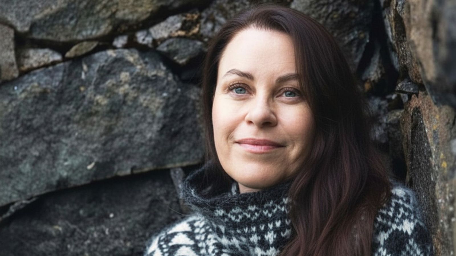 Sif Sveinsdottir, psykoterapeut og musikterapeut i Aalborg, foran en stenvæg